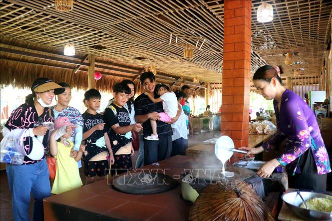Du khách tìm hiểu cách làm bánh cuốn ở Làng du lịch Mỹ Khách (huyện Phong Điền). Ảnh: Thu Hiền - TTXVN